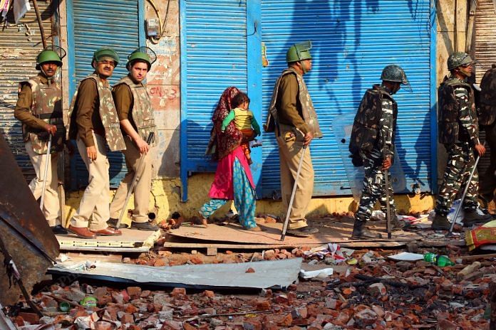 Delhi Police escort a woman and a child to a safe place during the Delhi riots that broke out in February 2020 | Suraj Singh Bisht | ThePrint