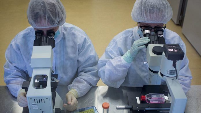 Lab technicians use microscope during production of the 'Gam-COVID-Vac' COVID-19 vaccine, developed by the Gamaleya National Research Center for Epidemiology and Microbiology and the Russian Direct Investment Fund (RDIF), in Zelenograd, Russia | Bloomberg