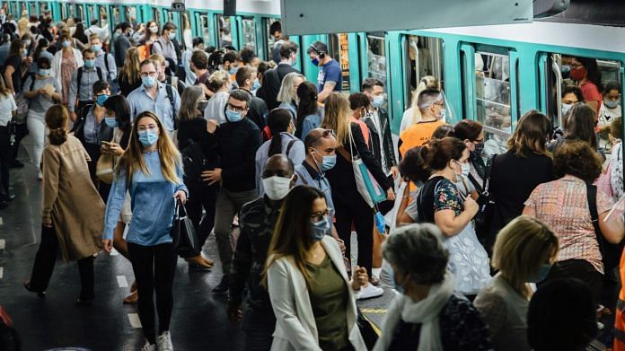 Morning rush hour commuters wear protective face masks while boarding and exiting a train at Saint-Lazare metro railway station in Paris, France. | Photographer: Cyril Marcilhacy | Bloomberg