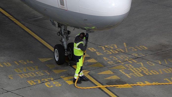 A ground crew member connects a fuel hose to an Airbus A321 aircraft | Photographer: Krisztian Bocsi | Bloomberg