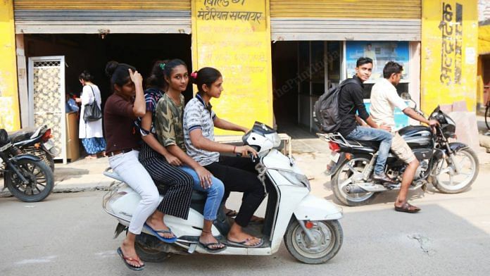 People ride triples on a scooter in Dabua colony, a containment zone in Faridabad, on 10 September 2020 | Manisha Mondal | ThePrint
