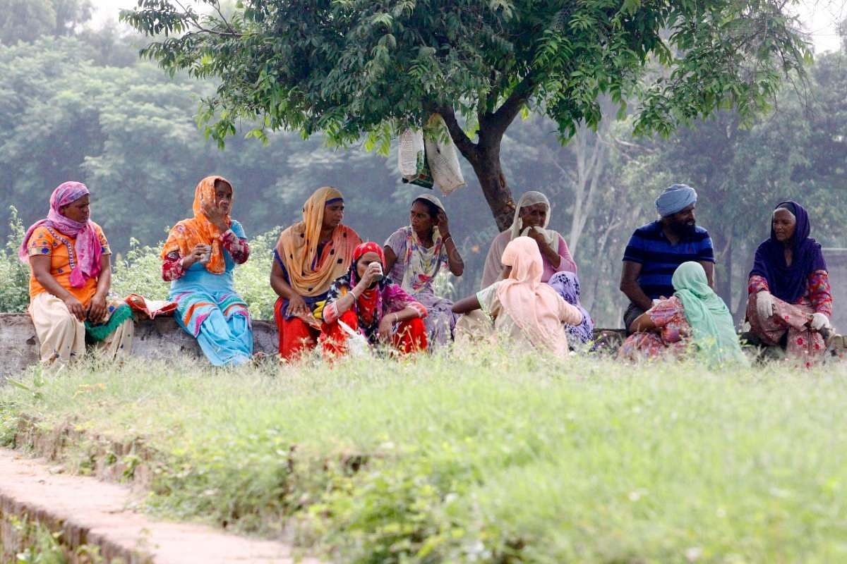 A group of villagers take a lunch break under a tree. No one can be seen using a mask | Praveen Jain | ThePrint