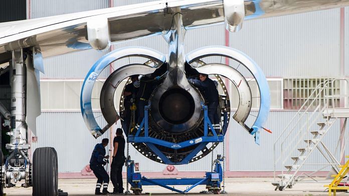 Workers carry out maintenance on a turbofan engine, manufactured by Rolls-Royce on a grounded aircraft at Chateauroux airport in France