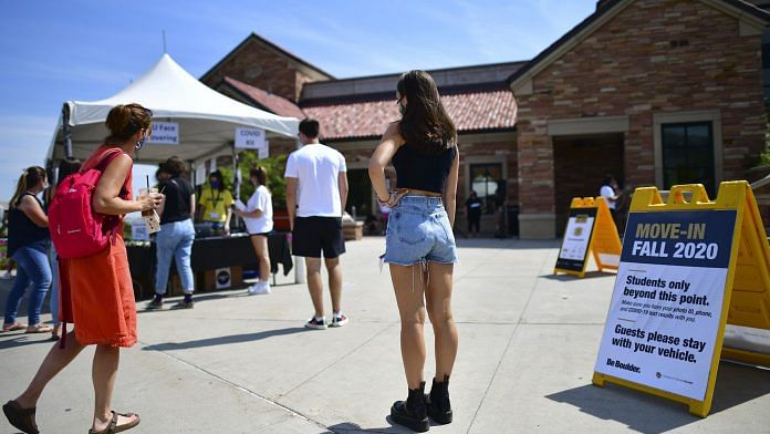 Incoming freshmen wait in line to ask questions at an informational tent while arriving on campus at University of Colorado Boulder on August 18