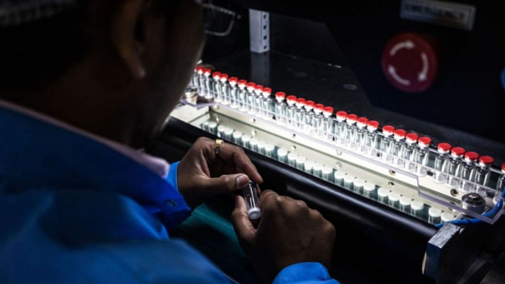 A technician inspects vaccine vials for defects during a screening process at the Serum Institute of India Ltd. pharmaceutical plant in Pune in 2015. | Photographer: Sanjit Das | Bloomberg