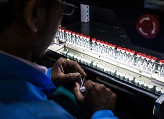 A technician inspects vaccine vials for defects during a screening process at the Serum Institute of India Ltd. pharmaceutical plant in Pune in 2015. | Photographer: Sanjit Das | Bloomberg