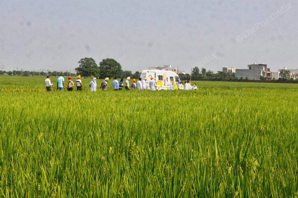 Villagers following the testing van in Sahnewal Village | Praveen Jain | ThePrint
