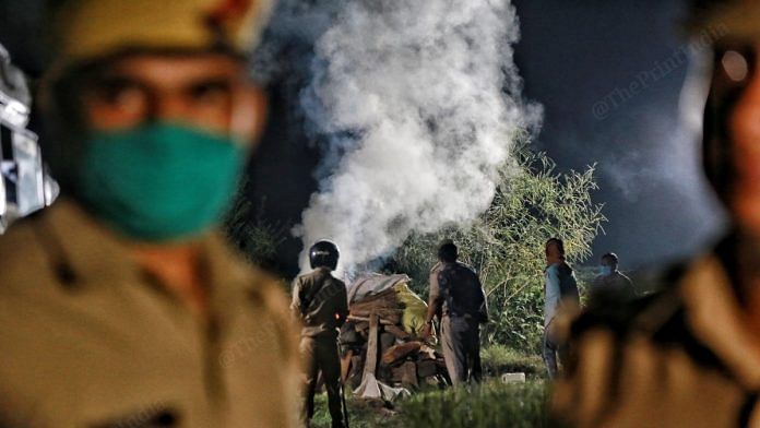 UP Police personnel burning the body of a 20-year-old Dalit woman in Hathras who was allegedly gangraped | Photo: Manisha Mondal | ThePrint