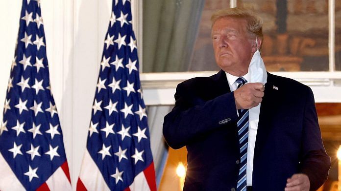 U.S. President Donald Trump removes his mask upon return to the White House from Walter Reed National Military Medical Center on 5 October, 2020 in Washington, DC. | Photographer: Win McNamee | Getty Images via Bloomberg