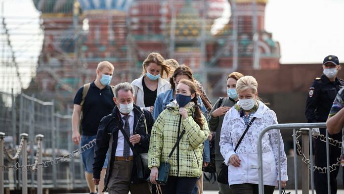I turisti indossano maschere di sicurezza sulla Piazza Rossa di Mosca, Russia  Bloomberg