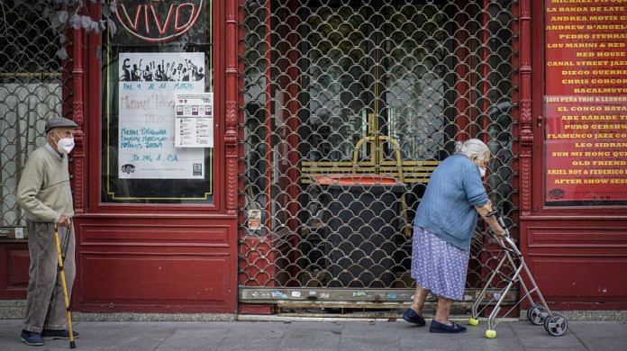 An elderly couple walk past a closed cafe in Plaza del Angel in Madrid, Spain | Representational Image | Bloomberg