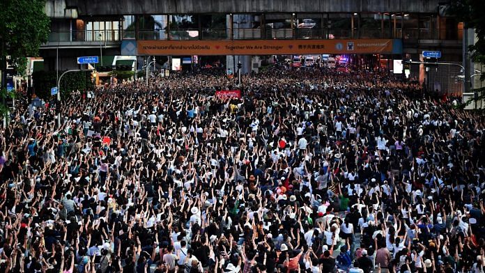 Pro-democracy protesters take part in a demonstration at a road intersection in Bangkok on 15 October 15 | Photo: Lillian Suwanrumpha | AFP via Getty Images | Bloomberg