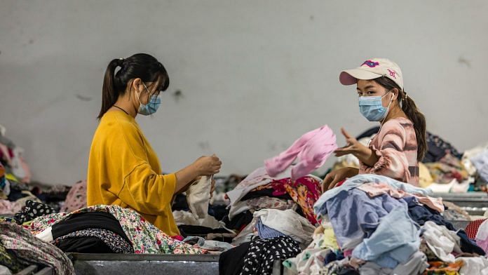 Employees sort second-hand apparel at Baijingyu’s facility in Hangzhou. Photo: Qilai Shen | Bloomberg