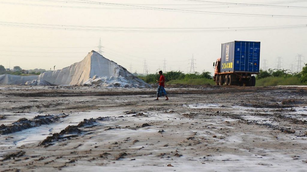 A worker walks in a wet salt pan in Maliya, Morbi, Gujarat | Photo: Manisha Mondal | ThePrint