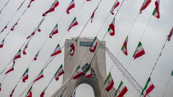 Iranian national flag bunting hangs in front of the Azadi Tower in Tehran