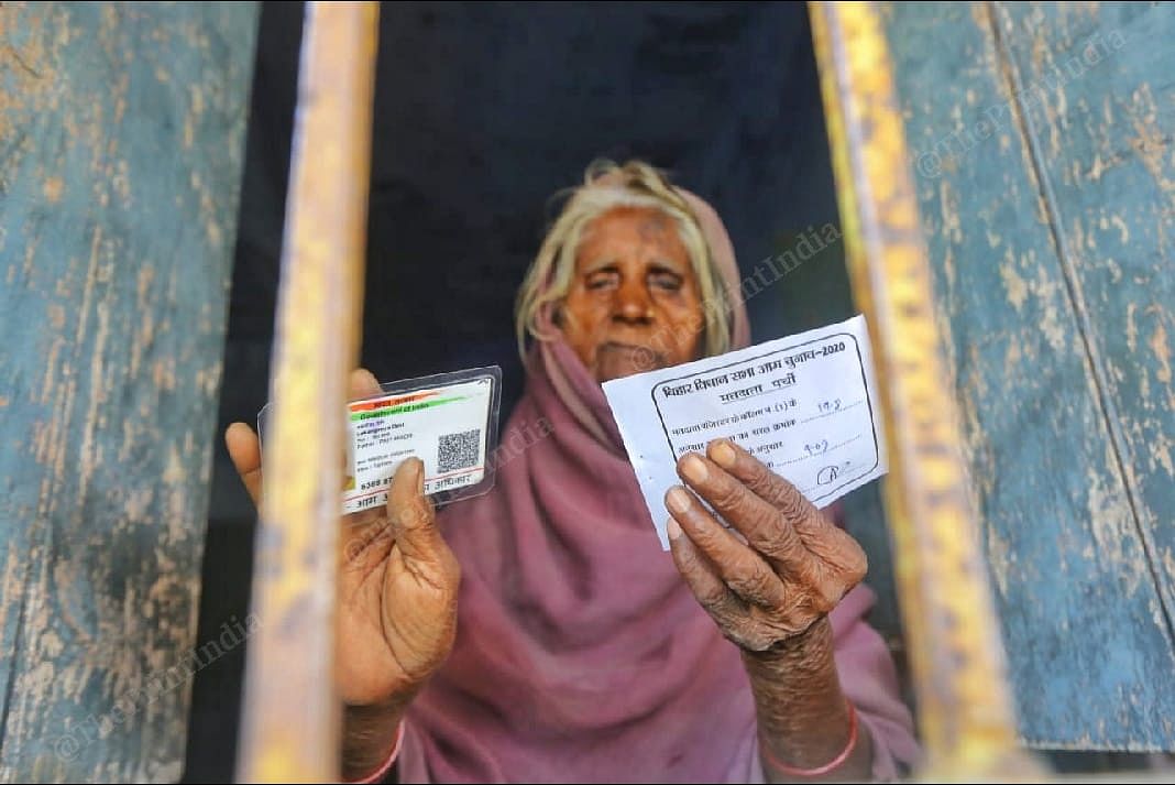 An elderly woman stands holding her Voter ID card in Belhori village | Praveen Jain | ThePrint 