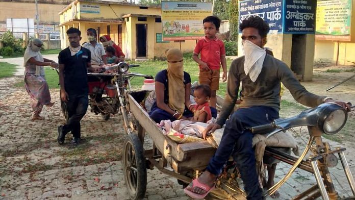 Kaushal Kumar (in front) and Ranjit Kumar with their families on the rickshaw carts that brought them home (Photograph taken in May) | By special arrangement