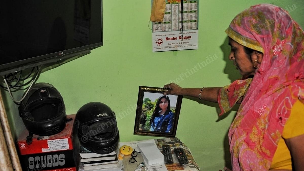 A family member of Nikita Tomar holds her picture at her home. | Photo: Suraj Singh Bisht/ThePrint