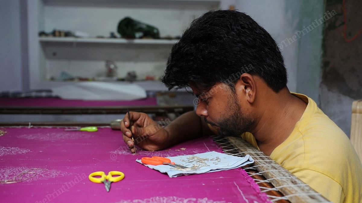 An artisan in Budaun's Sheikhupur village working on a zari lehenga, the sales of which have been hit due to the pandemic. | Photo: Suraj Singh Bisht/ThePrint