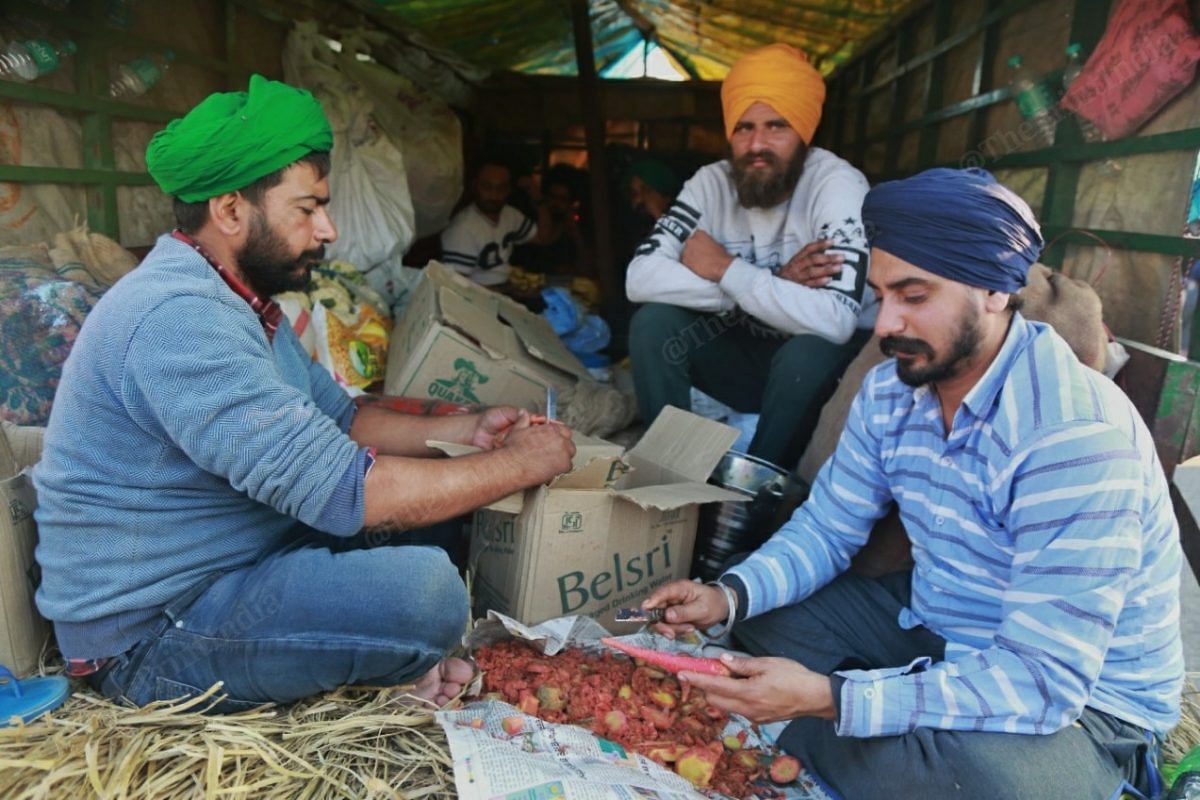 Men cut vegetables to prepare for dinner | Photo: Manisha Mondal | ThePrint