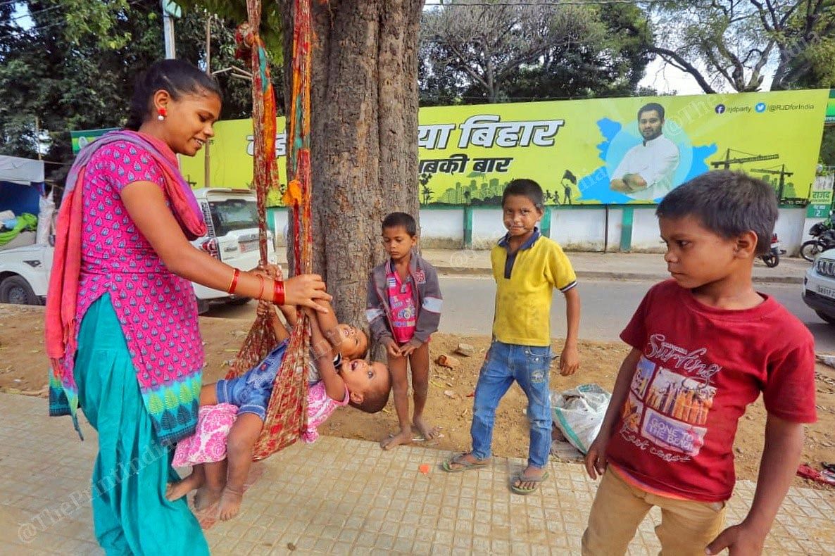 Underprivileged kids play against the huge hoarding of Tejashwi Yadav in the background | Praveen Jain | ThePrint