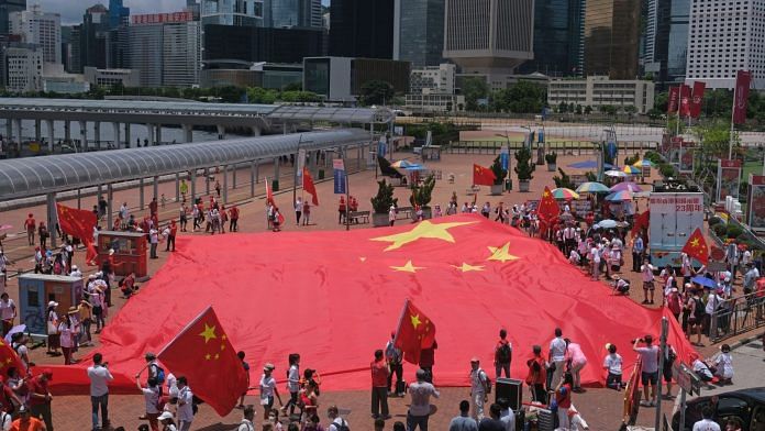 Government supporters display a Chinese flag during a rally to celebrate the 23rd anniversary of Hong Kong's return to Chinese rule on July 1, 2020. | Photographer: Roy Liu | Bloomberg