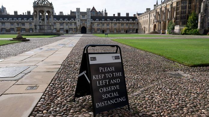A sign advising people to maintain social distancing the Great Court at Trinity College, part of the University of Cambridge, in Cambridge. | Photographer: Jutin Tallis | AFP | Getty Images via Bloomberg