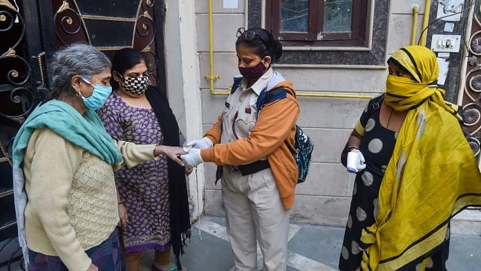Volunteers use an oximeter to measure the oxygen level during a door-to-door campaign to check symptomatic Covid-19 residents, amid rise in coronavirus cases, in East Delhi, on 22 Nov., 2020. | PTI