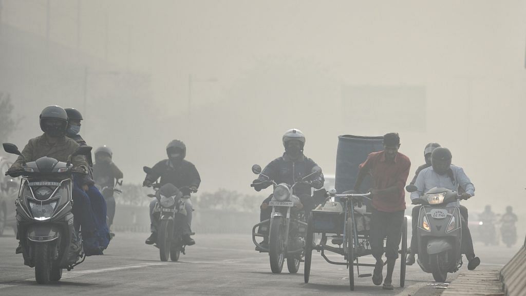 Commuters on two-wheelers plying through a thick layer of smog in New Delhi on 10 November | ANI Photo