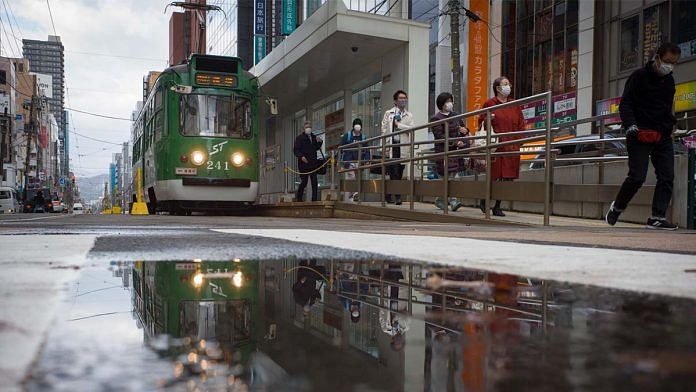 Commuters get off a tram at a station in Sapporo, Hokkaido, Japan on 5 November | Photo: Kentaro Takahashi | Bloomberg