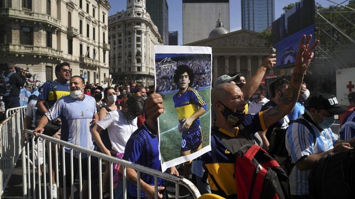 People wait in line to pay tribute to the late Argentine football star Diego Maradona, outside the Casa Rosada presidential palace in Buenos Aires, Argentina 26 November | Photo via Bloomberg