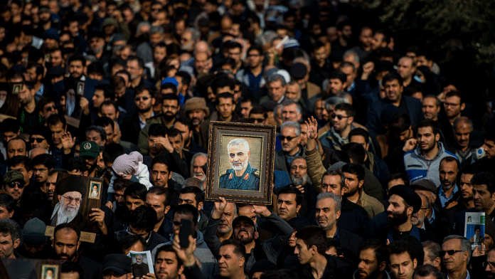 Protesters hold up an image of Qassem Soleimani, an Iranian commander, during a demonstration following the US airstrike in Iraq which killed him | Photographer: Ali Mohammadi/Bloomberg