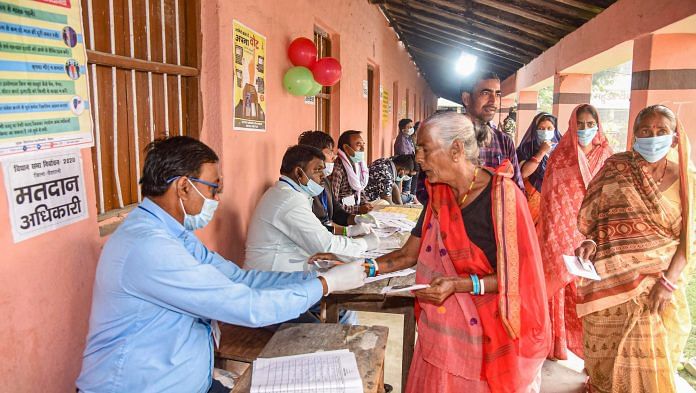 An election officer applies indelible ink on the finger of an elder voter at a polling station in Vaishali on 7 November