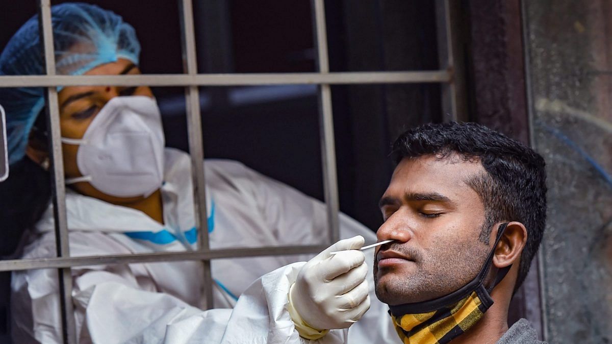 A health worker, wearing PPE kit, collects a sample for Covid-19 test, in New Delhi, Tuesday, 24 Nov., 2020. | PTI