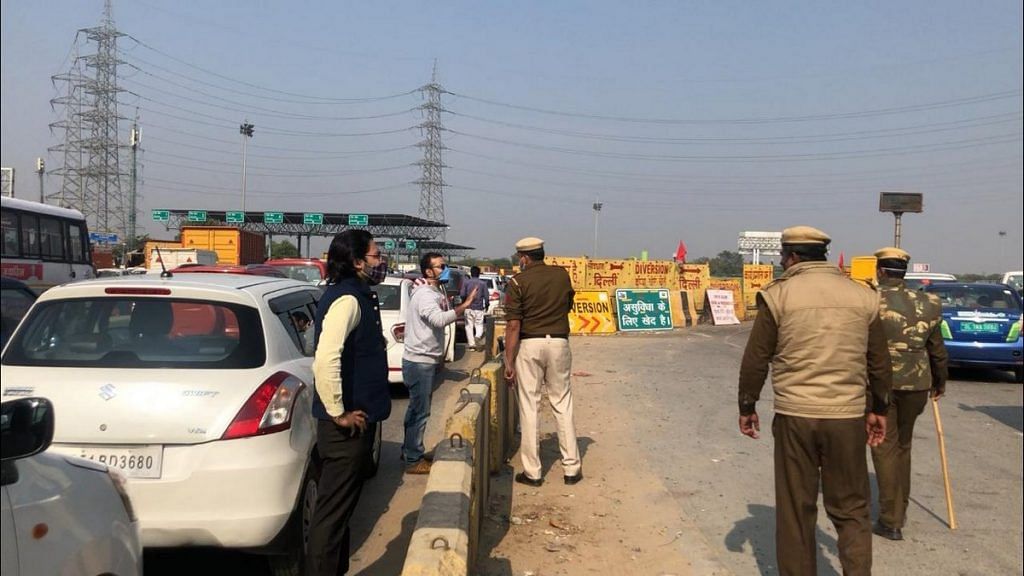 Commuters argue with police personnel at the Delhi-Gurugram border Thursday | Photo: Taran Deol | ThePrint