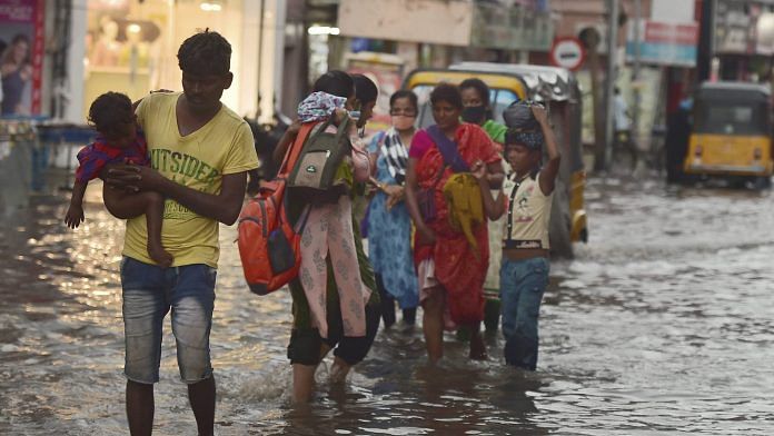 Pedestrians wade through a waterlogged road during heavy rain triggered by Cyclone Nivar, in Chennai, Tuesday, Nov. 24, 2020. | PTI