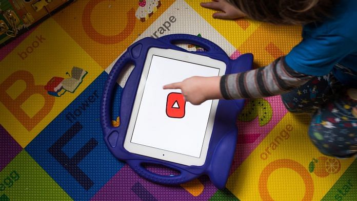 A child interacts with the YouTube Kids application on an iPad