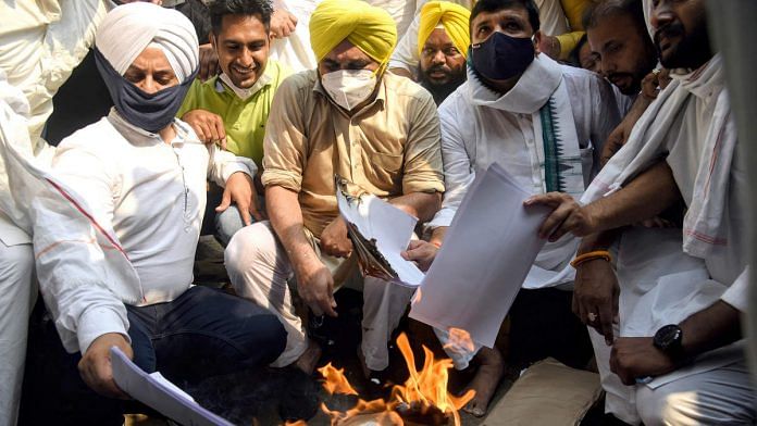 AAP leaders including its Punjab unit chief Bhagwant Mann (second from left) burn copies of the three new farm laws in New Delhi in October | Photo: ANI