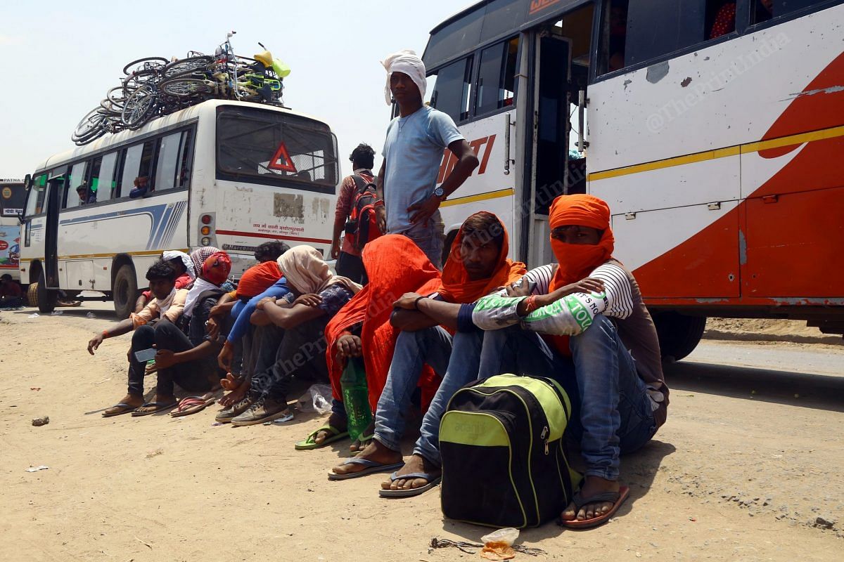 Migrant workers travelling from Banaras to Bihar wait for their turn to board the bus. Their temperature and other details were taken before they would leave | Photo: Suraj Singh Bisht | ThePrint