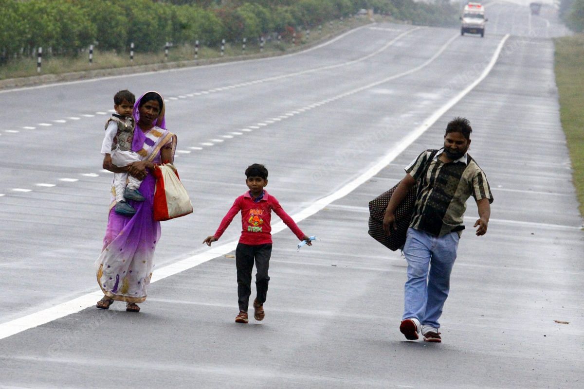 A family walks on the Agra highway from Delhi as they could not get any vehicle | Photo: Praveen Jain | ThePrint