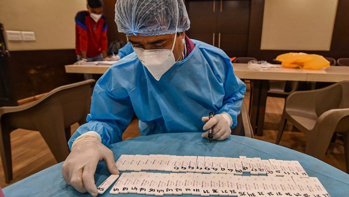 A health worker arranges slides while conducting Covid-19 sampling, at DDCA in New Delhi on 18 December | PTI Photo
