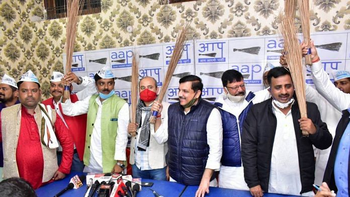 Senior AAP leader Sanjay Singh (centre, in dark blue jacket) and Congress leaders who have switched sides pose with the party's symbol, brooms | By special arrangement