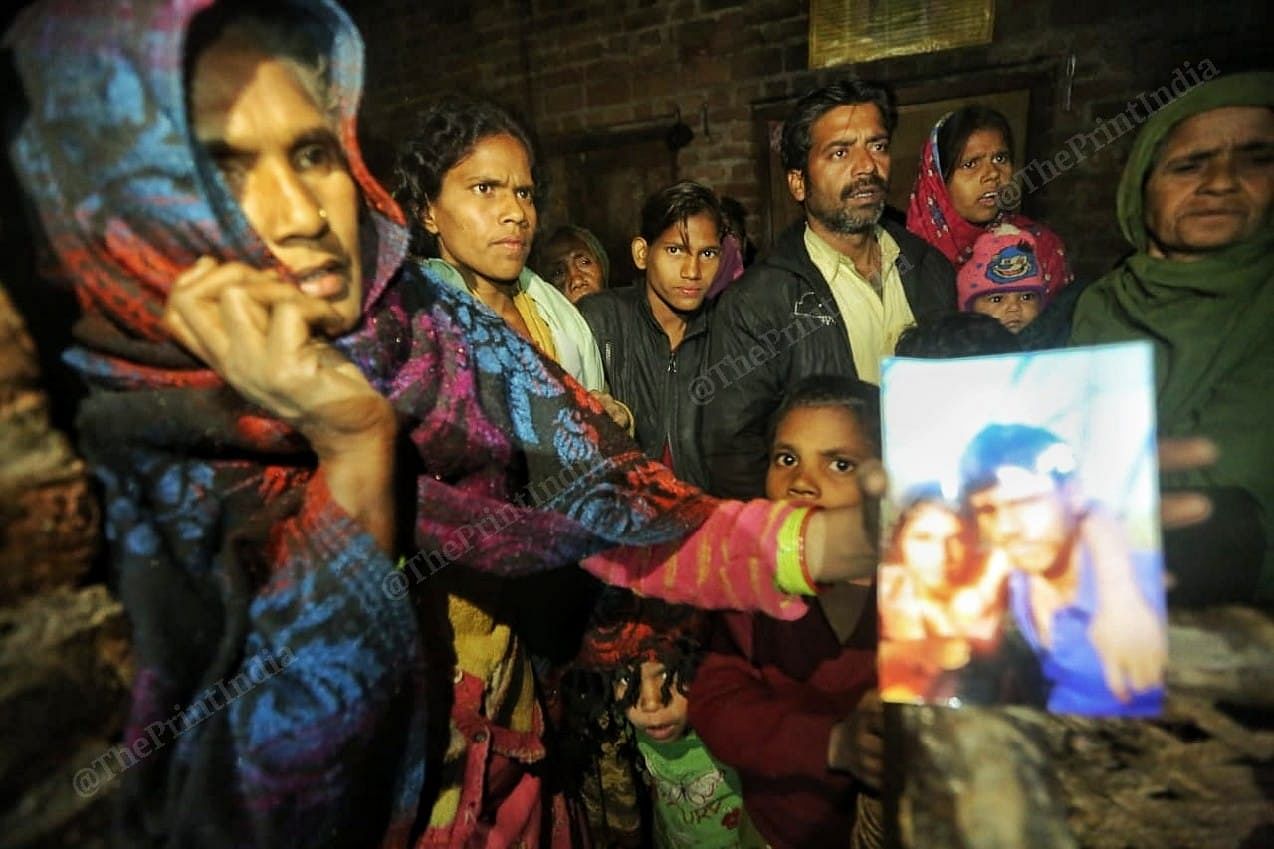 The family of Mohammad Azad hold up a photo of the couple | Photo: Praveen Jain | ThePrint