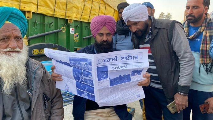 Farmers at Delhi's border reading a copy of the first edition of bi-weekly newsletter Trolley Times. | Photo: Revathi Krishnan/ThePrint