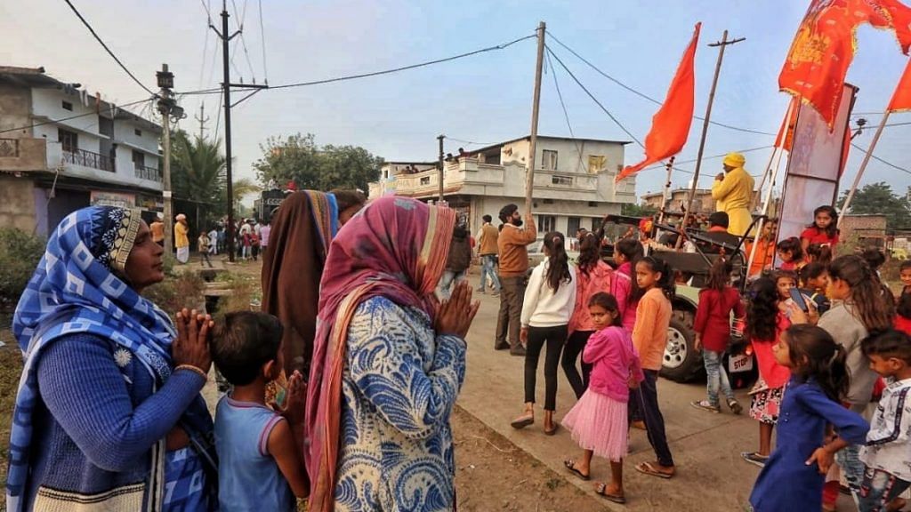 Women stand with folded hands as the awareness rally organised by Hindu groups like VHP pass by to promote the upcoming fundraising drive for the construction of Ram Mandir in Ayodhya | Photo: Praveen Jain | ThePrint