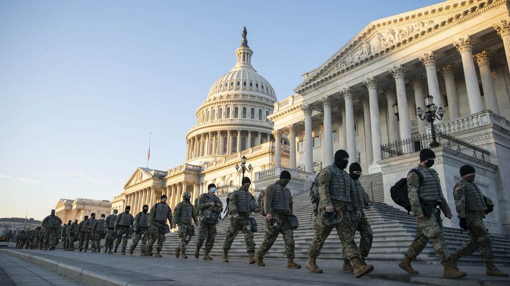 Members of the National Guard walk outside of the U.S. Capitol building in Washington, D.C., U.S., on Wednesday, Jan. 13, 2021. | Bloomberg