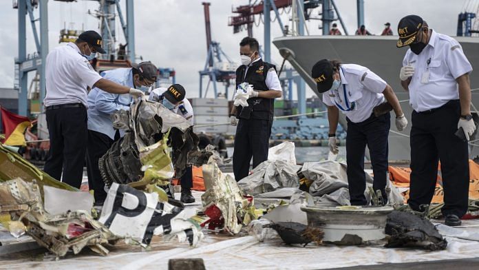 The National Transportation Safety Committee examine debris in Jakarta | Bloomberg