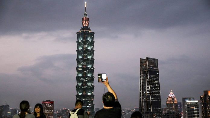 People take photographs of the Taipei 101 building and other buildings illuminated at dusk in Taipei (Representational photo) | Photographer: I-Hwa Cheng | Bloomberg