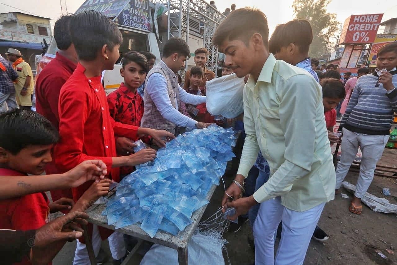 Soon after the rally ended kids try and grab water pouches | Photo: Praveen Jain | ThePrint