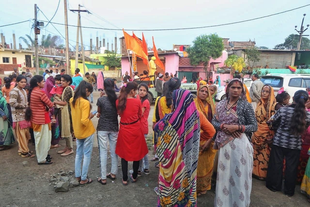 Residents stand across the street to catch a glimpse of the rally | Photo: Praveen Jain | ThePrint